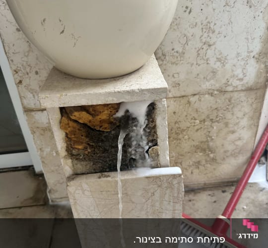 מים זורמים מתוך קיר אבן עם סבון
